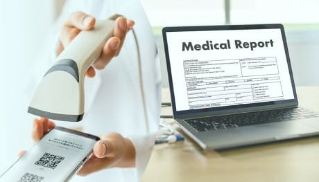 QRコードの読み取りと「Medical Report」と書かれたノートパソコン
